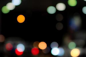 fondo abstracto bokeh azul, naranja, verde, rojo y blanco borroso. desenfoque bokeh sobre fondo oscuro. luz de la ciudad en la noche. navidad o fondo de navidad. efecto de luz de calle con hermoso patrón foto