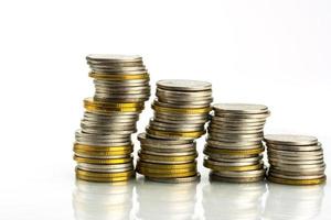 Macro shot detail of golden and silver color coin stacks on white background with copy space for text. Business and finance growth, saving money, investment and interest concept. photo