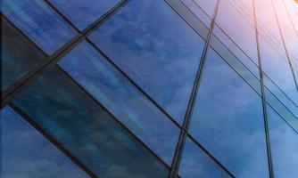 Perspective view of modern futuristic glass building abstract background. Exterior of office glass building architecture. Reflection in transparent glass of business building. Company glass window.