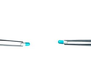 Two forceps pick white-blue capsule pills. Drugs choose for test in lab. Antibiotic drug selection. Antibiotic drug resistance concept. QA and QC in pharmaceutical factory concept. Drugs of choice. photo