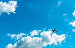 aerolínea comercial volando sobre cielo azul y nubes blancas esponjosas. bajo la vista del vuelo del avión. avión de pasajeros después de despegar o ir al vuelo de aterrizaje. viajes de vacaciones al extranjero. transporte aéreo. foto