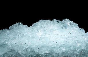 Pile of crushed ice cubes on dark background with copy space. Crushed ice cubes foreground for beverages, beer, whisky, fruit juice, milk, fresh food or fresh vegetables. photo