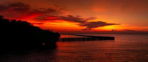 hermoso cielo rojo y naranja al atardecer sobre el mar tropical. cielo rojo del atardecer. horizonte en el mar. mar tropical vista panorámica del cielo del atardecer. océano en calma marina. imagen artística de la capa de nubes en el cielo del atardecer. foto