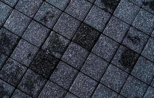 Black and grey rough paving stone texture background. Dark background for death, sad, hopeless and despair concept. Pavement architecture. Paving abstract texture. Paving slabs. Rough street floor.