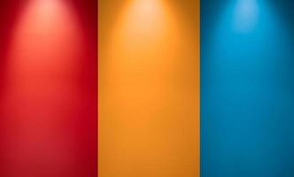 Empty red, orange or yellow and blue wall with spotlights. Illuminated lamp light. Room interior with ceiling lamp light and colorful wall. Studio wall texture background photo