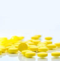 Yellow tablets pills isolated on white background with copy space. Pile of medicine. Painkiller tablets pills. photo