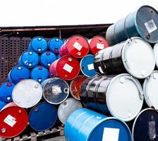 Stack of old chemical barrels. Blue, black and red oil drum. Steel and plastic oil tank. Toxic waste warehouse. Hazard chemical barrel. Industrial waste in drum. Hazard waste storage in factory. photo