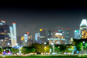 Bokeh de fondo borroso del paisaje urbano. edificio del centro financiero y de negocios con luz nocturna. colorido fondo bokeh de la ciudad. edificio de oficinas de arquitectura moderna. rascacielos con cielo de noche. foto