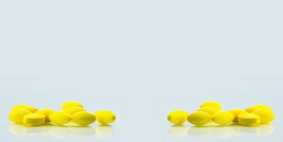 Píldoras de tabletas ovaladas amarillas con sombras sobre fondo blanco con espacio de copia para texto. Manejo del dolor leve a moderado. medicamento analgésico. foto