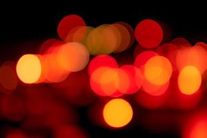 Blur red and orange bokeh on dark background. Abstract background of city light. Bokeh light with pattern of circle bokeh. Red and yellow light on black. Defocused bokeh light in the city at night. photo
