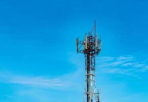 Telecommunication tower with blue sky and white clouds background. Antenna on blue sky. Radio and satellite pole. Communication technology. Telecommunication industry. Mobile or telecom 4g network. photo