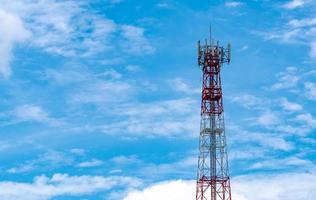 Telecommunication tower with blue sky and white clouds background. Antenna on blue sky. Radio and satellite pole. Communication technology. Telecommunication industry. Mobile or telecom 4g network. photo