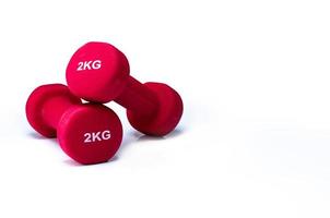 Set of red dumbbells isolated on white background. A pair of red neoprene dumbbells. Home gym equipment for exercise at home. Weight training equipment for sculpt arms, shoulders, back, and legs. photo