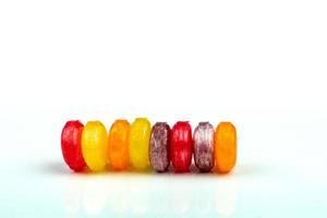 Medical lozenges for relief cough, sore throat and throat irritation isolated on white background. Cough and colds drop. Colorful cough pastille. Red, orange, yellow, and purple round candy or sweets. photo