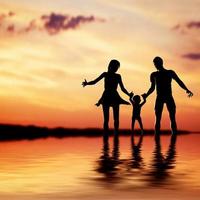 Happy family walking together hand in hand at sunset. Mother, father, child. photo