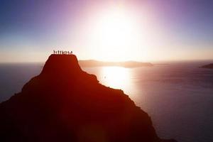 Happy group of people, friends, family on the top of the mountain over ocean celebrating success photo