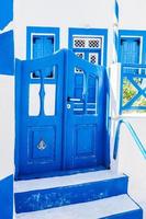 Traditional Greek stone house, blue gate and window shutters, Santorini island, Greece. photo
