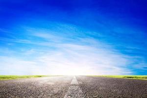 Long empty asphalt road, highway towards sun photo