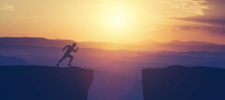 Man running towars cliff in the mountains. photo