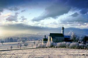 Alpine scenery with church in the frosty morning photo