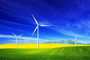 Wind turbines on spring field. Alternative, clean and natural energy photo