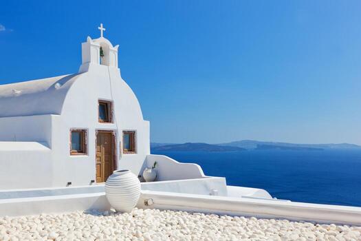 ciudad de oia en la isla de santorini, grecia. iglesia blanca y jarrón. foto