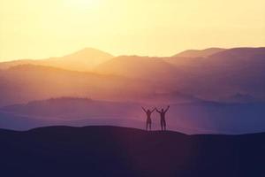 Happy man and woman standing on a hill photo