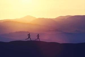 Man and woman running on a hill in the country photo