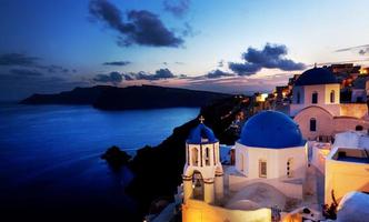 Oia town on Santorini island, Greece at night. Rocks on Aegean sea. photo