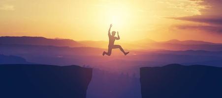 Man jumping above the cliff in the mountains. photo