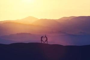 pareja joven creando un corazón fuera de sus cuerpos foto