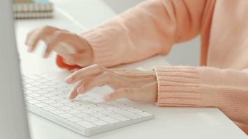 Young woman working at a desk with a computer keyboard. video