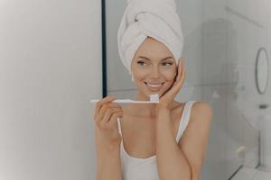 Attractive happy young girl with perfect white wide smile brushing her teeth photo