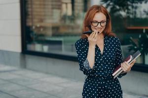 Woman makes online voice record for sending audio message poses outdoor photo