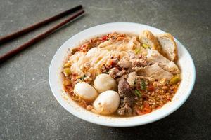 noodles with pork and meatballs in spicy soup photo