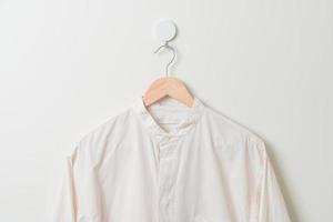 hanging shirt with wood hanger on wall photo