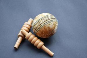 Old training cricket sport equipments on dark floor, leather ball, wickets, helmet and wooden bat, soft and selective focus, traditional cricket sport lovers around the world concept. photo