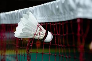 Badminton sport equipments on green floor shuttlecocks, rackets, shoes, selective focus on shuttlecocks, badminton sport playing lover concept. photo