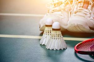 Badminton sport equipments on green floor shuttlecocks, rackets, shoes, selective focus on shuttlecocks, badminton sport playing lover concept. photo