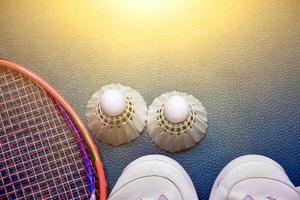 Badminton sport equipments on green floor shuttlecocks, rackets, shoes, selective focus on shuttlecocks, badminton sport playing lover concept. photo