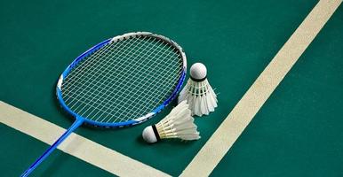 Badminton sport equipments on green floor shuttlecocks, rackets, shoes, selective focus on shuttlecocks, badminton sport playing lover concept. photo