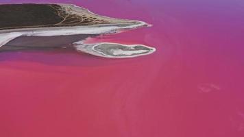 Aerial view of White salt on the shores of the island in Pink Island and blue sky . Lake Lemuria, Ukraine. Lake naturally turns pink due to salts and small crustacean Artemia in the water photo