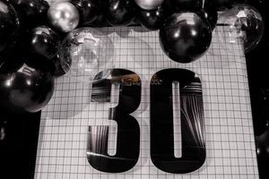 decoración de cumpleaños trigésimo aniversario con globos negros y plateados foto