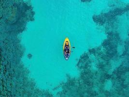 Aerial view of yellow kayak in blue lagoon at summer. photo