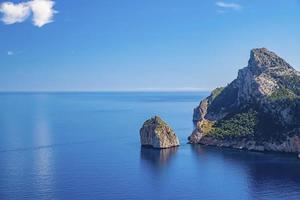 Picturesque view of Mediterranean sea and rocky cliff in island against blue sky photo