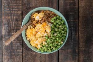 Egg fried rice and bean in green bowl on wood table. photo