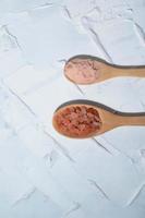 Pink himalayan salt in spoon on white table. photo