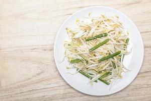 Healthy vegetarian food fried bean sprout in plate on wood table. photo