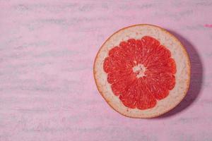 Healthy fruit good food grapefruit on pink table. photo