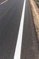 White and yellow line on new asphalt road photo